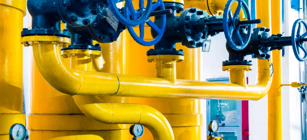 Metalowy cylinder na stacji pomp w przemysłowym otoczeniu komunalnym, prezentujący zaawansowaną technologię i inżynierię w transporcie rurociągowym.