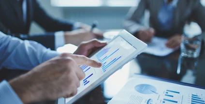Pracownik umysłowy używający technologii do nauki podczas spotkania zarządzania pracą. Gestykulujący i współpracujący za pomocą urządzenia komunikacyjnego.